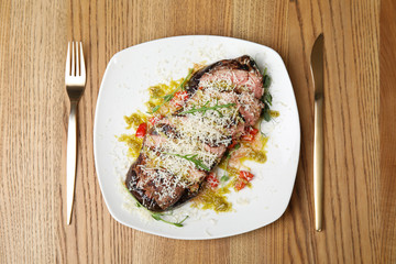 Delicious roasted meat served on wooden table, flat lay