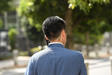 A Japanese security man with special earphones in a business outfit in front of the government district in Osaka-Japan.