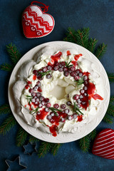 Christmas meringue cake Pavlova with cranberry and rosemary. Top view with copy space.