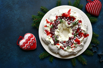 Christmas meringue cake Pavlova with cranberry and rosemary. Top view with copy space.