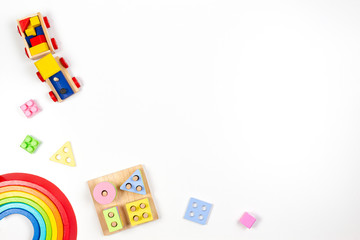 Baby kids toys background. Wooden educational geometric stacking blocks toy, wood rainbow, and colorful blocks on white background. Top view, flat lay