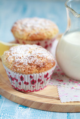 Close-up of two homemade lemon muffins with a jug of milk, selective focus