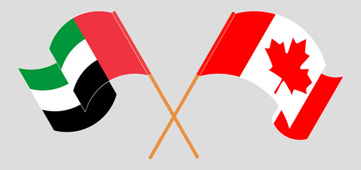 Crossed and waving flags of Canada and the United Arab Emirates