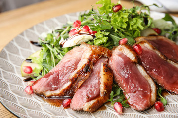Delicious salad with roasted duck breast on plate, closeup