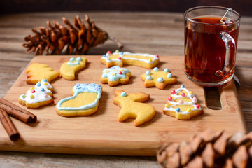 Gingerbread and christmas cookies and festive decor with hot tea on wooden background with a place for text
