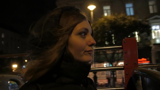 Girl on a night tour open top bus dark scene young woman traveler