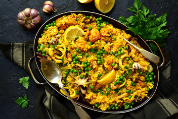 Paella - traditional dish of spanish cuisine in a skillet. Top view with copy space.