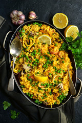 Paella - traditional dish of spanish cuisine in a skillet. Top view with copy space.
