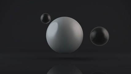 3D rendering of a large glowing white sphere and two black balls placed side by side. The objects are in a dark Studio. Abstract composition of ideal figures, a combination of white and black.