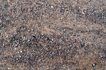 Detail of surface texture with small pebble rock on dirty ground