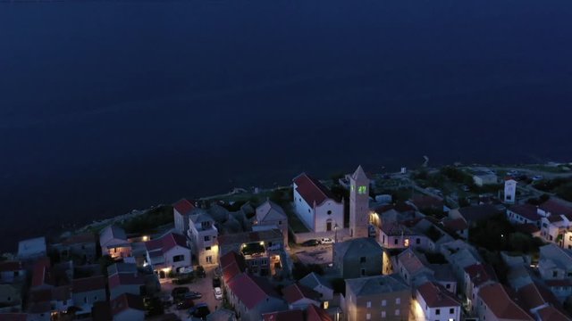 Tranquil Vinjerac, Croatia lit up at dusk, long slow retreating aerial