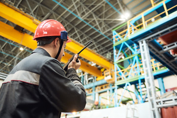 industrial worker on factory with walkie talkie transmitter