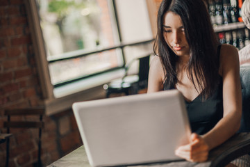 Business woman working on a laptop in a cafe.