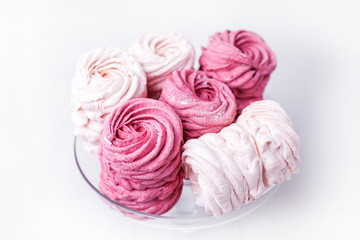 Obraz na płótnie Canvas pink and white marshmallows on a white plate