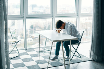 man sitting on chair and working on his laptop