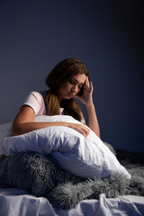 Sad tired female in the bed with pillow want to sleep