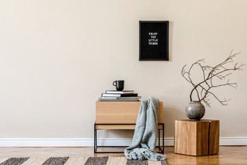 Modern scandinavian living room interior with mock up poster frame, design wooden commode, tea pot, wooden cube, flowers and elegant accessories. Beige concept. Stylish home decor. Ready to use. 