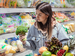 A young woman buys groceries in a supermarket.