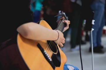 Mano de chica tocando la guitarra en evento