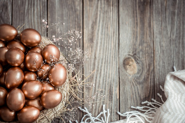 Background with Golden Easter eggs on wooden background.