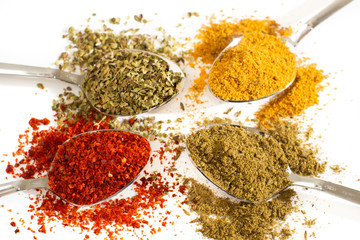 various spices. red pepper, black pepper and curry on white background