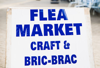 Fototapeta premium Flea Market Craft and Bric--a-brac Collectables Today sign with an arrow point to the right, towards a jumble sale car boot or charity shop sales table in the country side. perfect for resellers