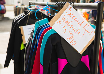 Second hand wetsuits starting from only £10 pounds on sale rack preowned so surfers swimmers bodyboards can all go into the cold sea and stay warm. Great for doing waterspouts in England