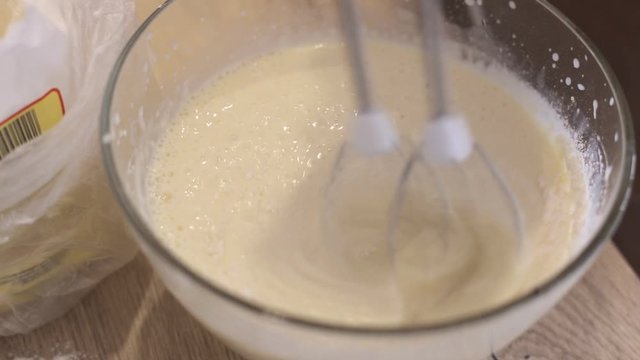 Adding flour into bowl and mix it with electric mixer