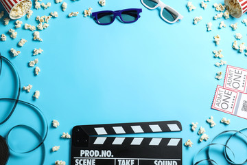 Flat lay composition with clapper board and cinema tickets on light blue background, space for text