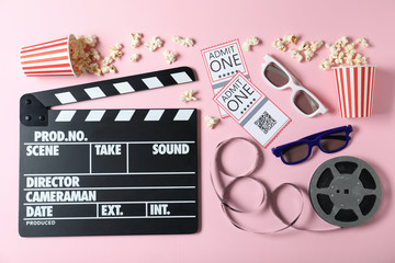 Flat lay composition with cinema tickets and clapperboard on pink background