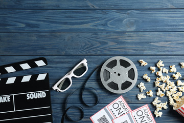 Flat lay composition with clapperboard and cinema tickets on blue wooden background, space for text