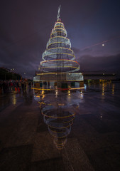 bonita árvore de natal metálica iluminada na cidade à noite