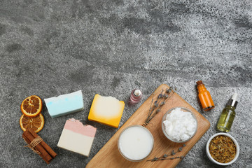 Fototapeta na wymiar Flat lay composition with natural handmade soap and ingredients on grey stone table, space for text