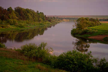 Obraz premium Sunny summer landscape with river.Green hills and meadows.Fields of ripe wheat.