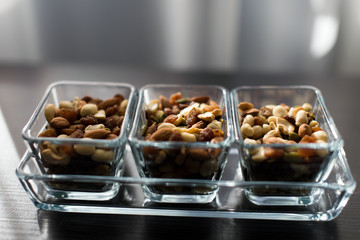 Raisins, peanuts and pistachio in elegant glass bowls