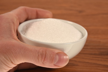 hands holding a bowl with sugar