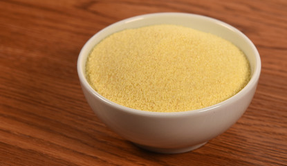 Semolina in a bowl on wooden background