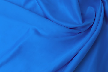 Textile and texture concept of trendy classic blue color in 2020 year. Sample of wavy silk fabric of classic blue color - closeup.