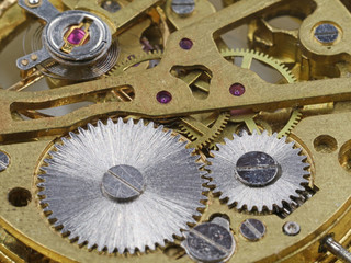 close up backside of clockwork mechanism of a golden pocket watch