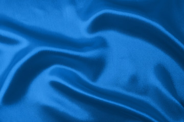 Textile and texture concept of trendy classic blue color in 2020 year. Sample of wavy silk fabric of classic blue color - closeup.