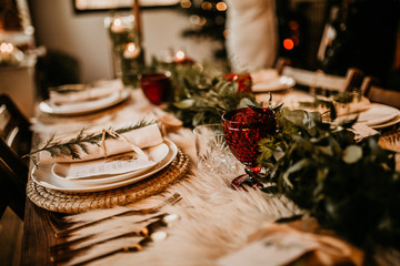 Christmas table setting for traditional lunch or dinner on a rustic table with seasonal greeting...