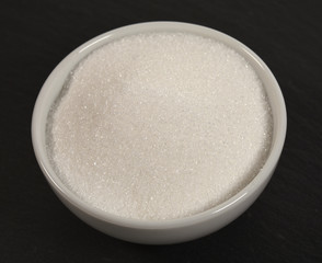 Sugar in a bowl isolated on black background