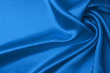 Textile and texture concept of trendy classic blue color in 2020 year. Sample of wavy silk fabric of classic blue color - closeup.