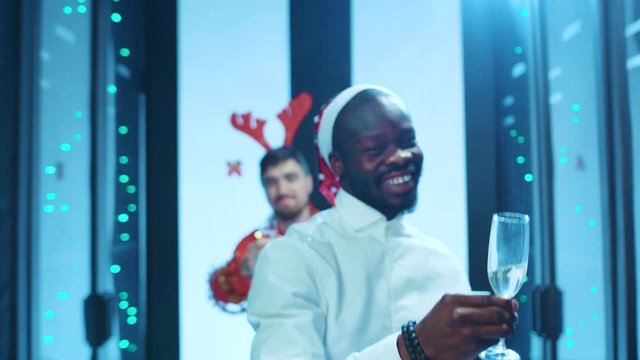 Row of attractive holiday people appearing in focus, celebrating happy Christmas time and toasting with drinks, enjoying winter corporate festive party in data center cyber security.