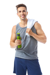 Sporty young man with bottle of water and towel on white background