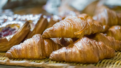 Assortment of freshly baked croissants for sale on counter of shop, market, cafe or bakery. Dessert, pastry, breakfast, sweet food and traditional french cuisine concept