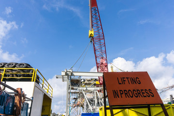 Offshore crane on board a construction work barge performing heavy lifting of a frame strcuture...