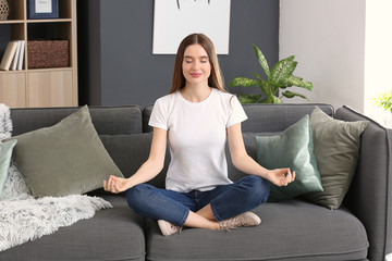 Beautiful woman meditating at home