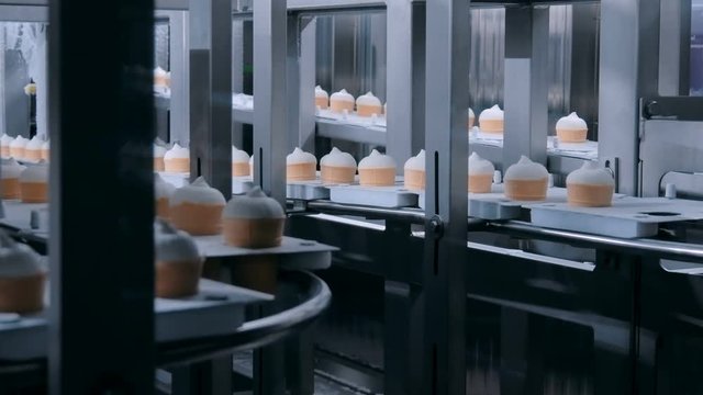 Icecream automatic production line - conveyor belt with ice cream cones at modern food processing factory. Food dairy industry, manufacturing, engineering and automated technology equipment concept