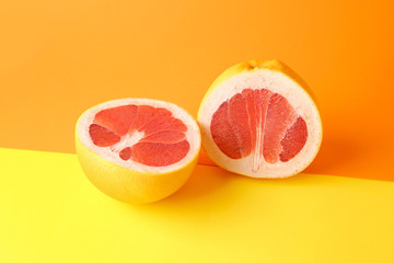 Fototapeta na wymiar Halves of fresh grapefruit on color background